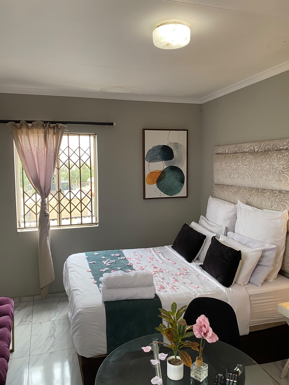 Room 4 bed dressed with fresh linen, towels and rose petals