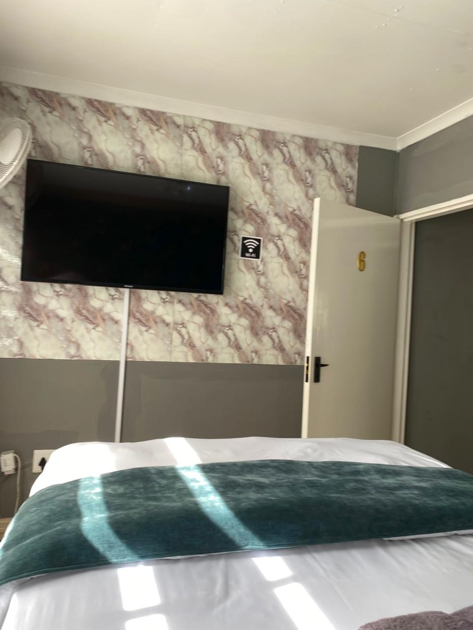Room 5 double bed with white linen and teal velvet throw