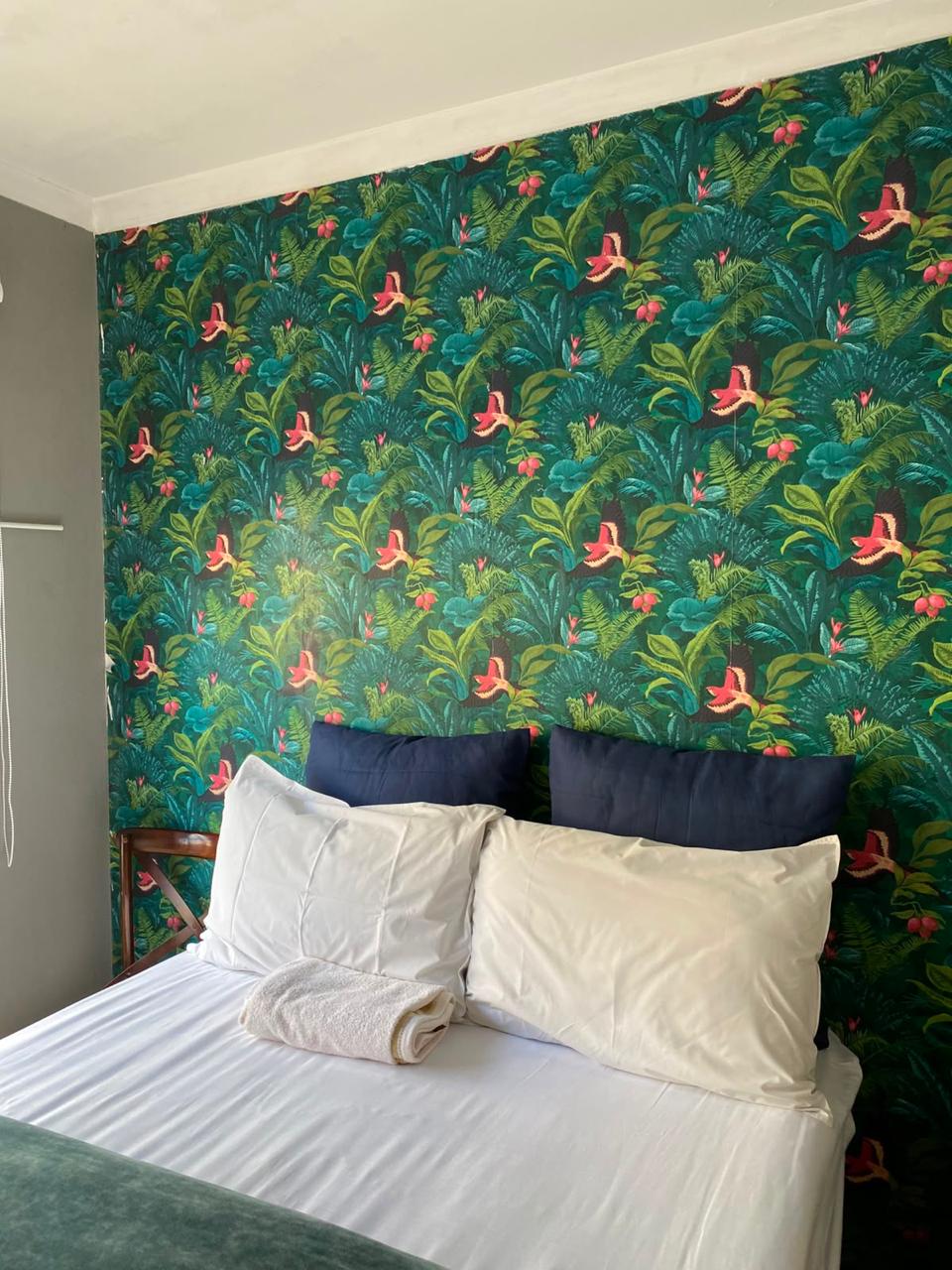 Room 5 tropical feature wall with navy and white pillows
